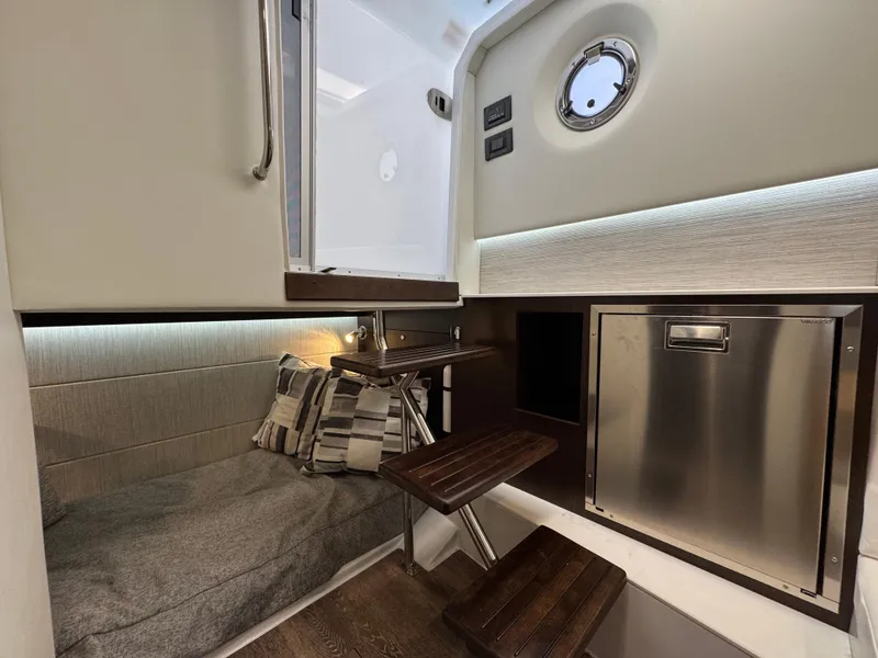 Slide: The Image of 2023 Cruisers Yachts 34 GLS I/O cabin interior with seating, steps, and porthole. - 56