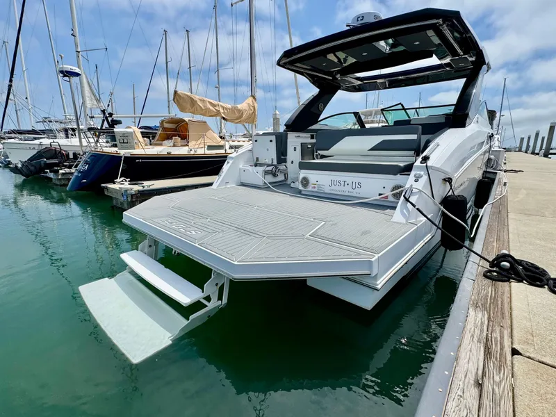 Slide: The Image of 2023 Cruisers Yachts 34 GLS I/O docked, showcasing sleek design and spacious swim platform. - 9