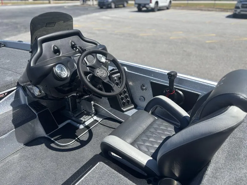 Slide: The Image of 2025 Phoenix 721 ZXL boat cockpit with steering wheel and seating in a parking lot. - 13
