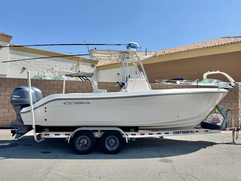 The Image of 2017 Cobia 237 Center Console boat on trailer, parked outdoors. - 0