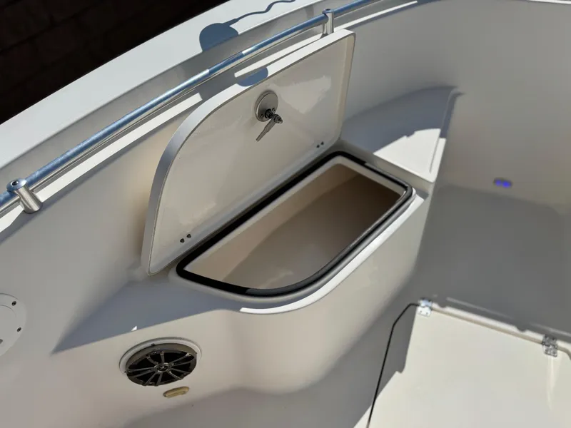 Slide: The Image of 2017 Cobia 237 Center Console boat storage compartment with open hatch and speaker. - 14
