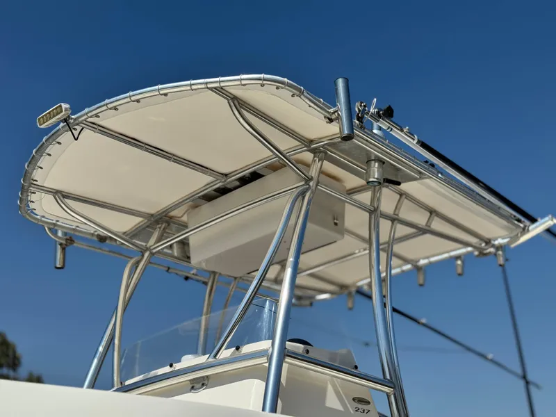Slide: The Image of 2017 Cobia 237 Center Console boat with T-top against clear blue sky. - 19