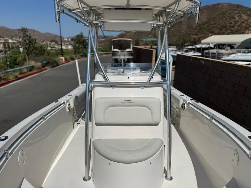 Slide: The Image of 2017 Cobia 237 Center Console boat with T-top, docked outdoors. - 22
