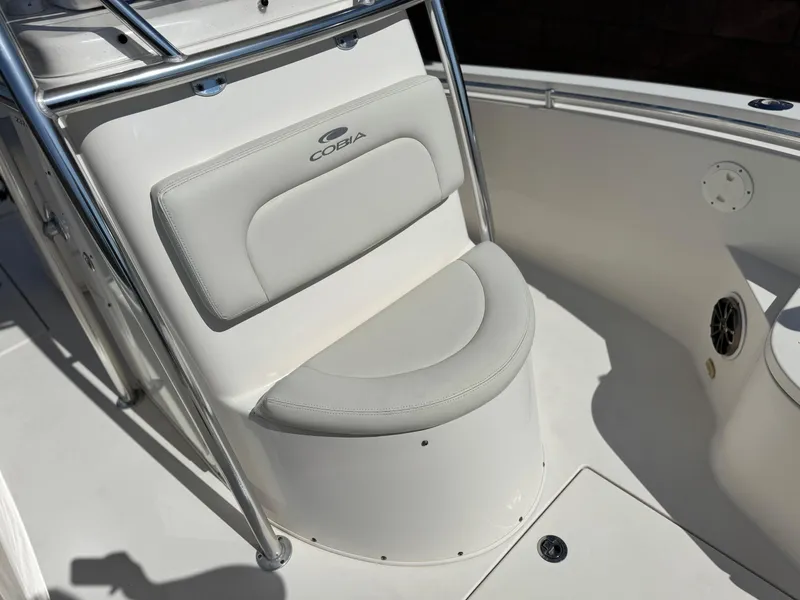 Slide: The Image of 2017 Cobia 237 Center Console boat seat with stainless steel frame and white upholstery. - 23
