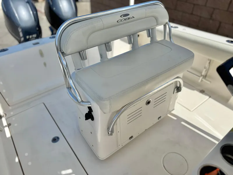 Slide: The Image of 2017 Cobia 237 Center Console boat with white seating and rod holders. - 31