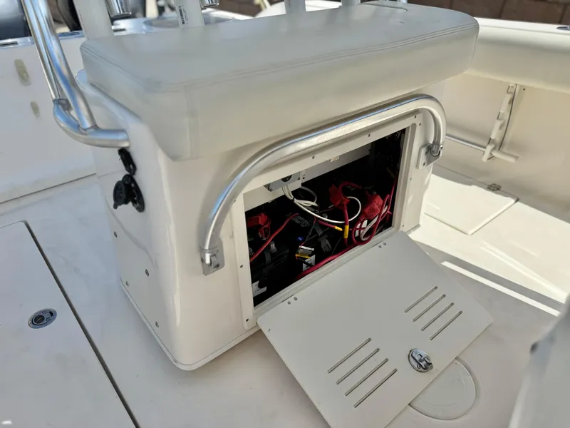Slide: The Image of 2017 Cobia 237 Center Console boat with open storage compartment, revealing wiring and equipment. - 32