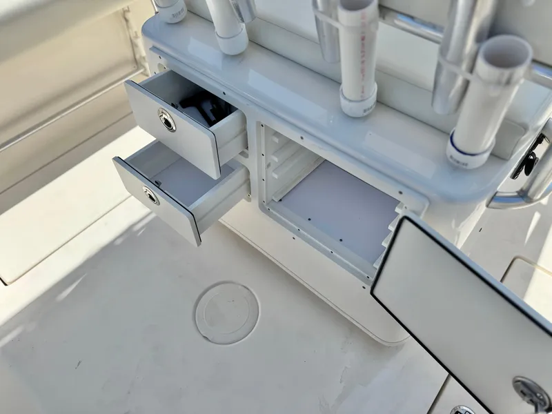 Slide: The Image of 2017 Cobia 237 Center Console storage compartments with open drawers and rod holders. - 36