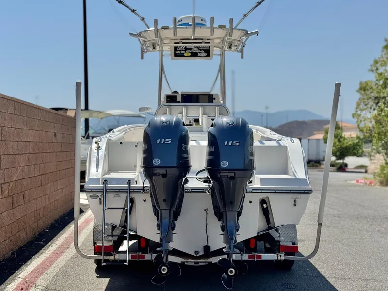 Slide: The Image of 2017 Cobia 237 Center Console boat with dual 115 HP engines, parked outdoors. - 4