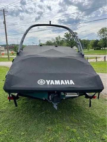 Slide: The Image of 2021 Yamaha AR195 boat with cover, parked on grass under cloudy sky. - 12