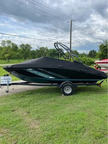 Slide: The Image of 2021 Yamaha Boats AR195 covered on trailer, parked on grass under cloudy sky. - 13