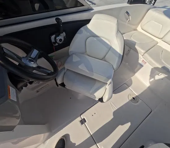 Slide: The Image of 2016 Chaparral 19 H2O Sport boat interior with steering wheel and white seating. - 14