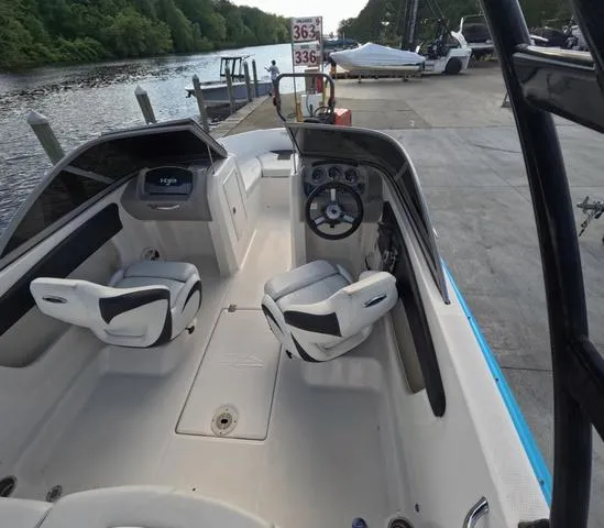 Slide: The Image of 2016 Chaparral 19 H2O Sport boat interior at dock, featuring dual seats and steering wheel. - 5