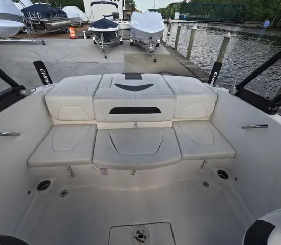 Slide: The Image of 2016 Chaparral 19 H2O Sport boat interior with white seating, docked by the water. - 6