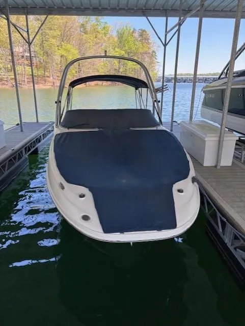 Slide: The Image of 2010 Sea Ray 260 Sundeck docked in a covered marina with scenic lake view. - 1