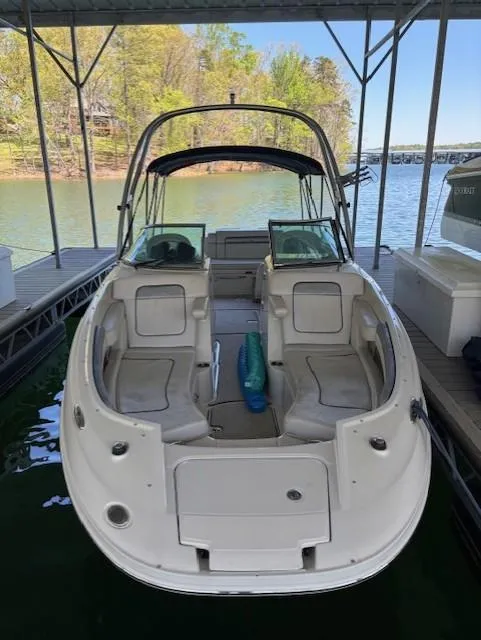 Slide: The Image of 2010 Sea Ray 260 Sundeck boat docked on a serene lake. - 2