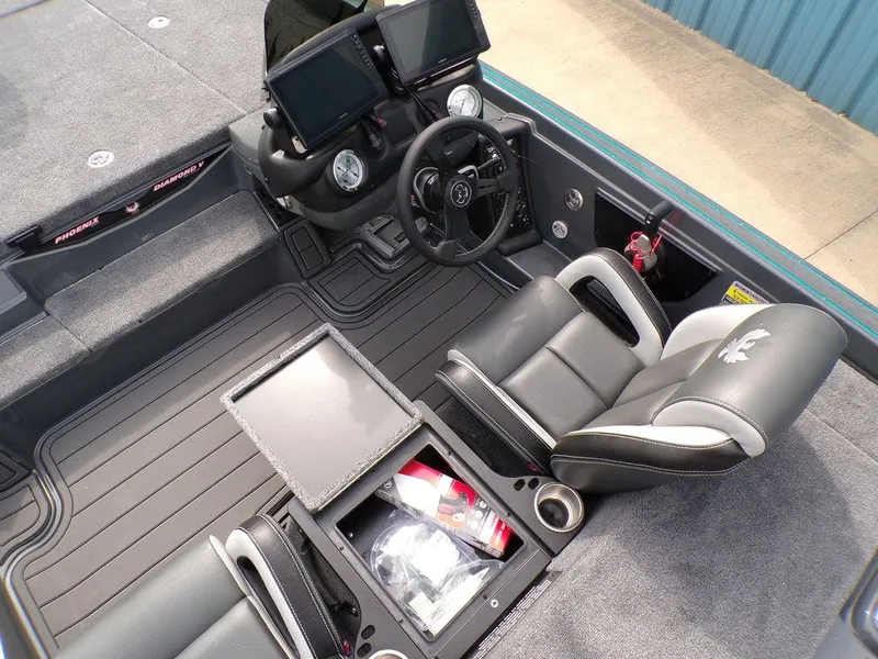 Slide: The Image of 2025 Phoenix 721 ZXL boat interior with dual screens, steering wheel, and storage compartments. - 2