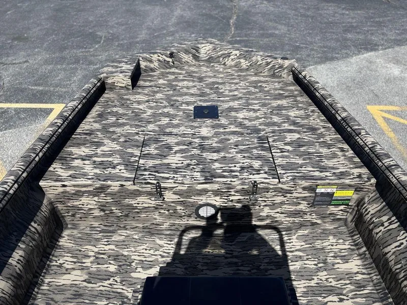 Slide: The Image of Camouflage-patterned deck of 2025 Havoc 1965 UCC boat, parked on asphalt. - 13