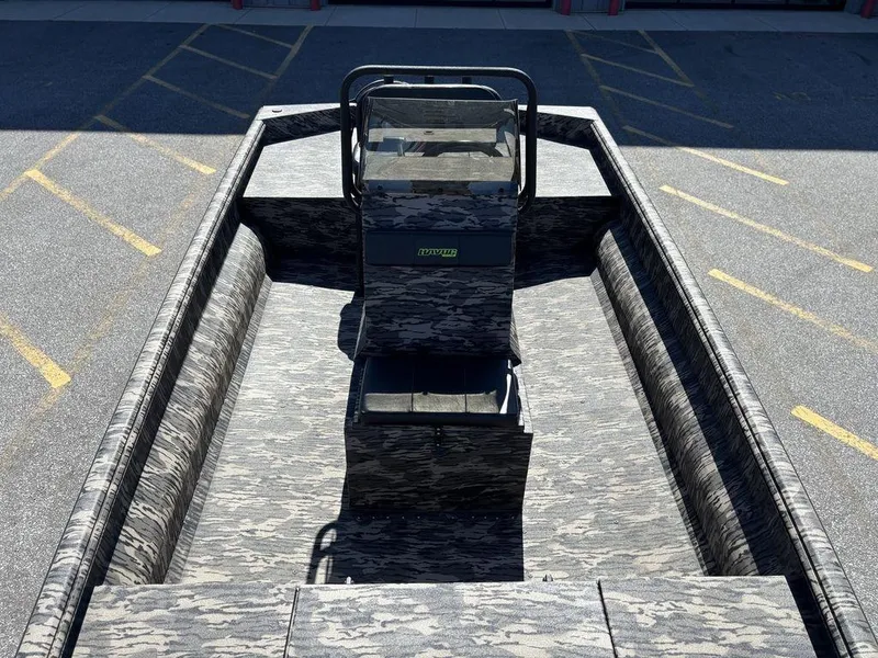 Slide: The Image of Camouflage-patterned 2025 Havoc 1965 UCC boat interior with central console, parked on asphalt. - 14