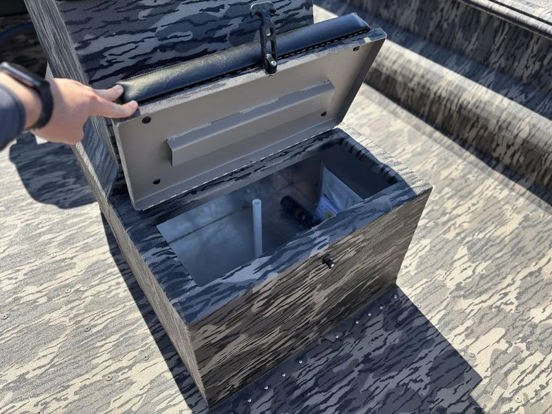 Slide: The Image of Open storage compartment in 2025 Havoc 1965 UCC boat, featuring camo design and secure latch. - 16
