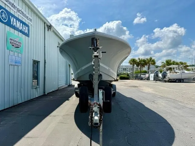 Slide: The Image of 2017 Regulator 31 boat on trailer outside Yamaha dealership under blue sky. - 2