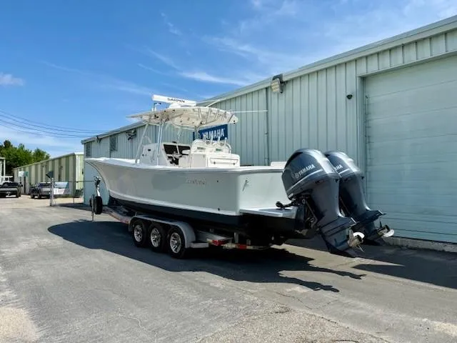 Slide: The Image of 2017 Regulator 31 boat on trailer with dual Yamaha engines, parked outside a warehouse. - 3