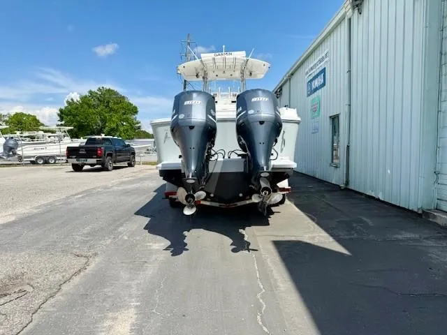 Slide: The Image of 2017 Regulator 31 boat with twin outboard motors parked near a building. - 4