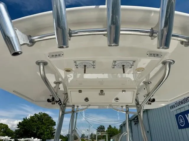 Slide: The Image of 2017 Regulator 31 boat T-top with rod holders and electronics, under a clear blue sky. - 8
