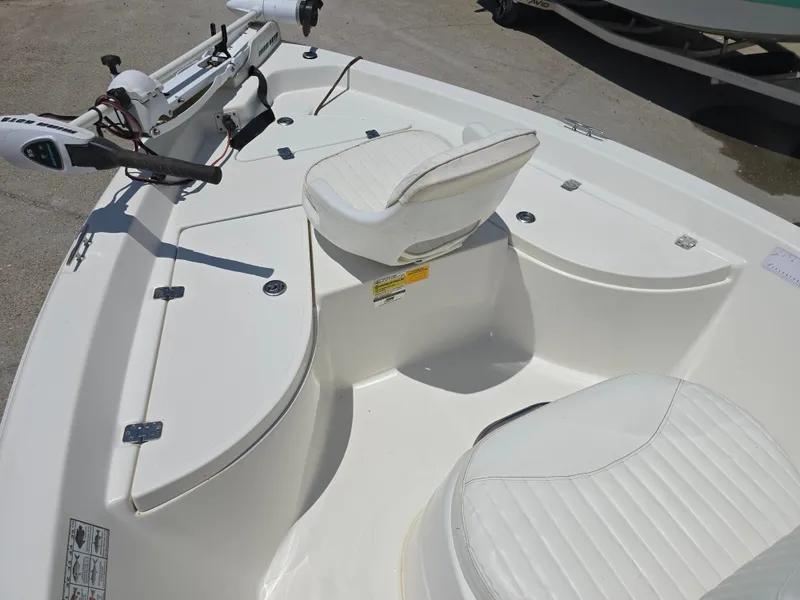 Slide: The Image of 2010 NauticStar 1810 Nautic Bay boat interior with white seating and trolling motor. - 13