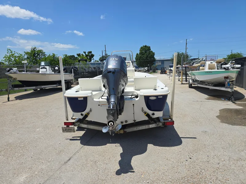 Slide: The Image of 2010 NauticStar 1810 Nautic Bay boat with outboard motor, parked outdoors on a sunny day. - 4
