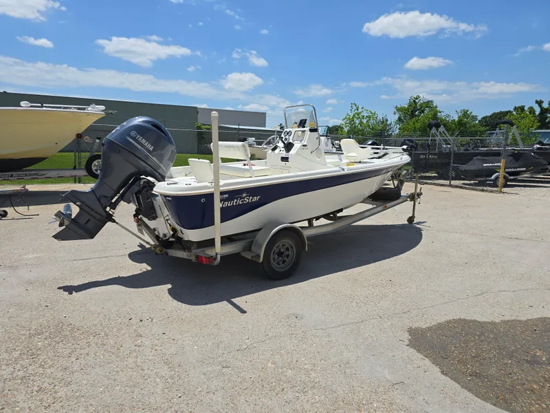 Slide: The Image of 2010 NauticStar 1810 Nautic Bay boat on trailer, parked outdoors under blue sky. - 5