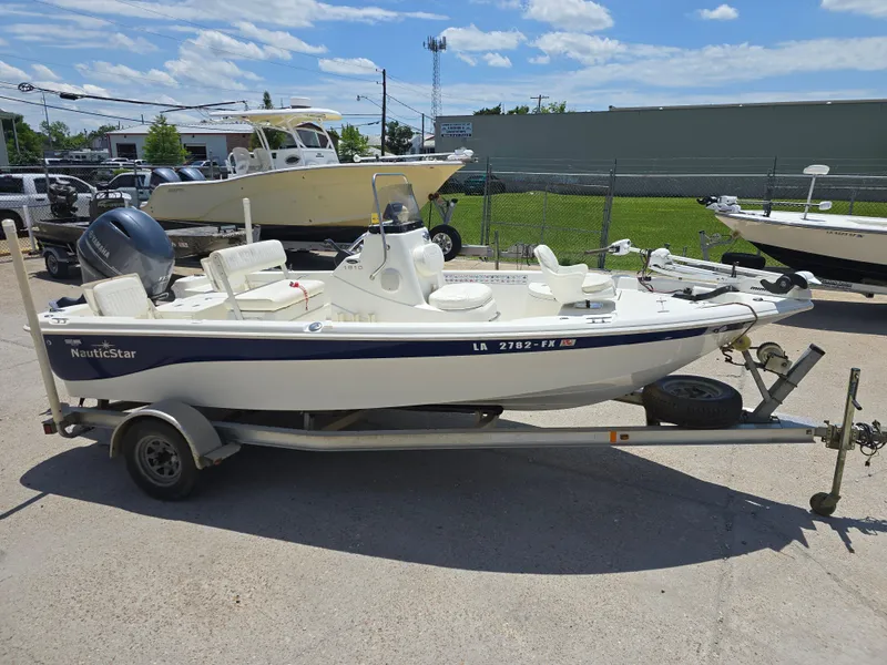 Slide: The Image of 2010 NauticStar 1810 Nautic Bay boat on trailer, parked outdoors under a clear sky. - 7