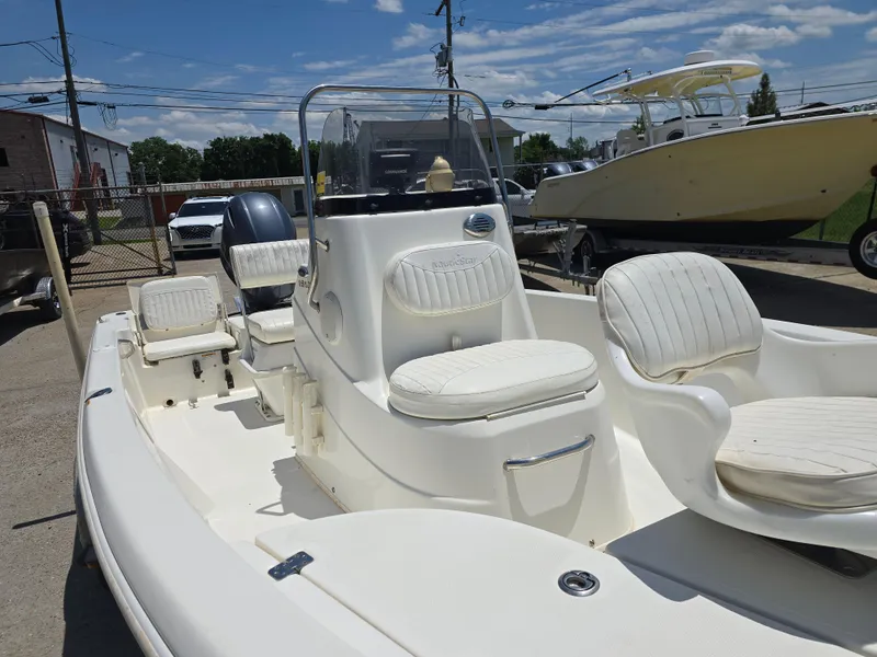 Slide: The Image of 2010 NauticStar 1810 Nautic Bay boat with white seating and console, parked outdoors. - 8