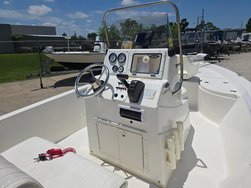 Slide: The Image of 2010 NauticStar 1810 Nautic Bay boat with steering console and gauges, parked outdoors. - 9