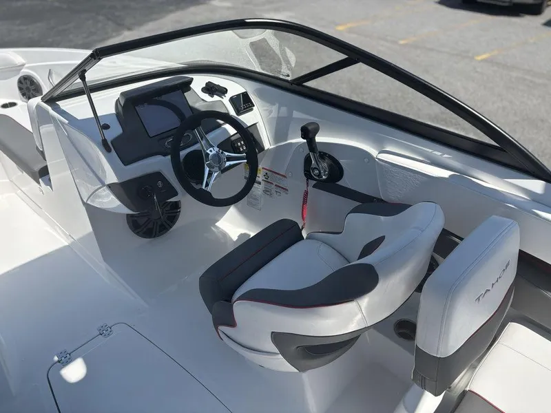 Slide: The Image of 2024 Tahoe 210 S boat interior with steering wheel and seating. - 12