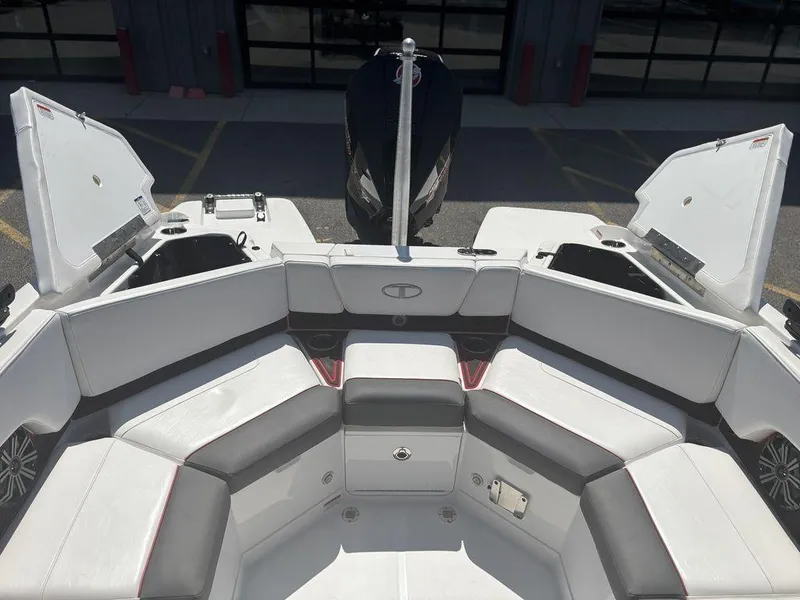 Slide: The Image of 2024 Tahoe 210 S boat interior with white and gray seating, open storage compartments. - 19
