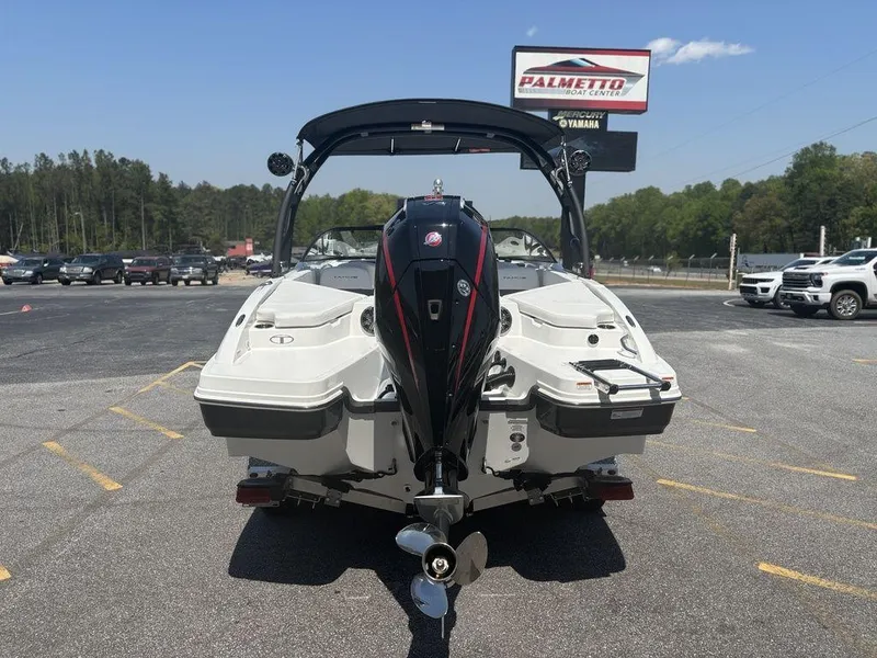 Slide: The Image of 2024 Tahoe 210 S boat, rear view, parked outdoors at dealership. - 4