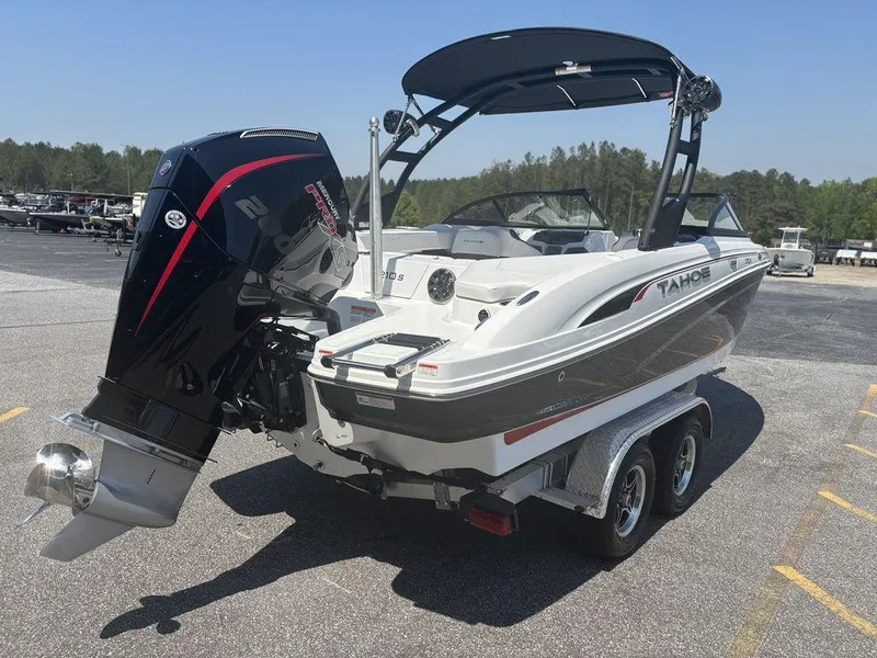 Slide: The Image of 2024 Tahoe 210 S boat on trailer, featuring powerful outboard motor, parked outdoors. - 5