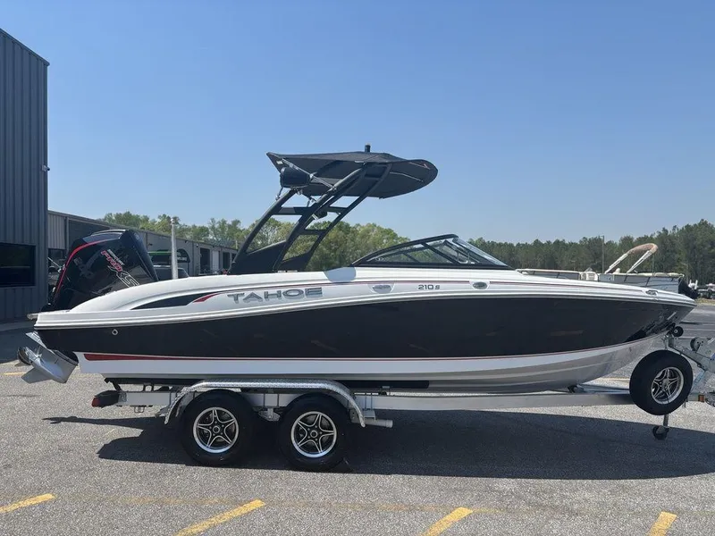 Slide: The Image of 2024 Tahoe 210 S boat on trailer, black and white design, parked outdoors. - 6
