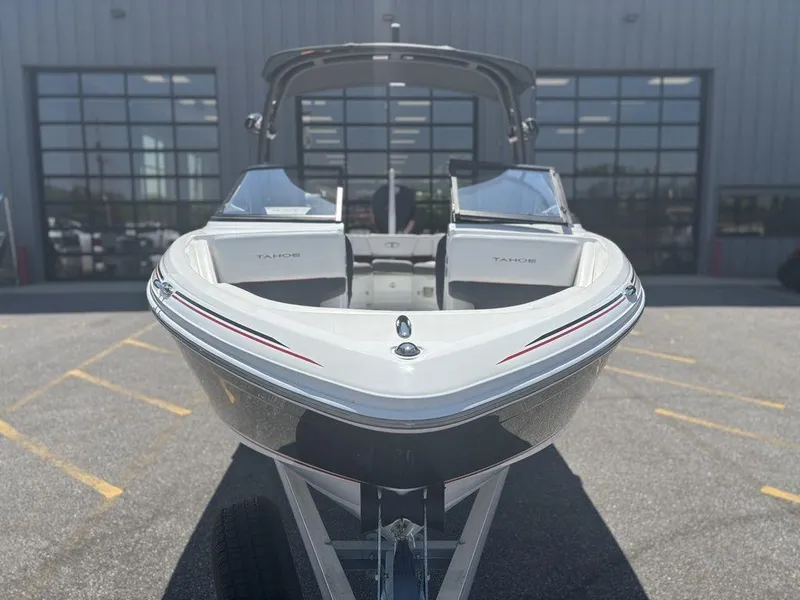 Slide: The Image of 2024 Tahoe 210 S boat, front view, parked outdoors near a building. - 8