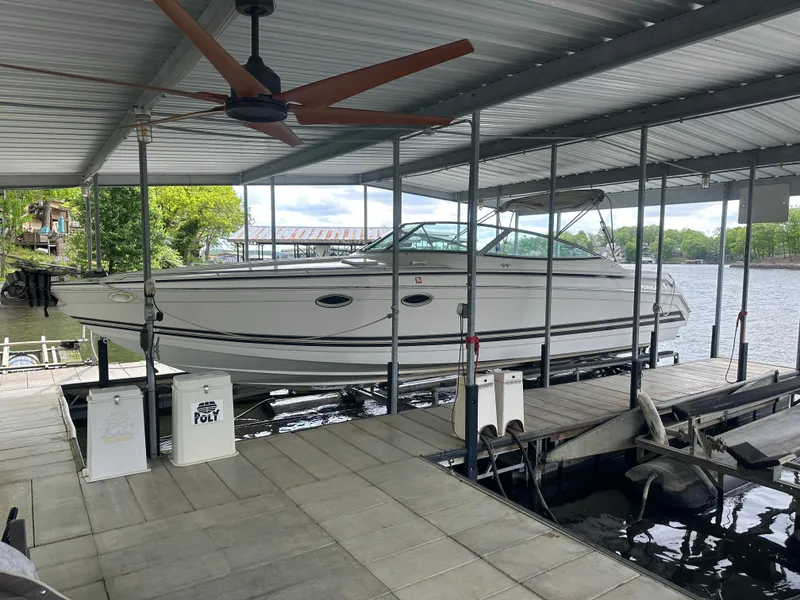 Slide: The Image of 1998 Formula 330 SunSport boat docked under a covered marina on a sunny day. - 1
