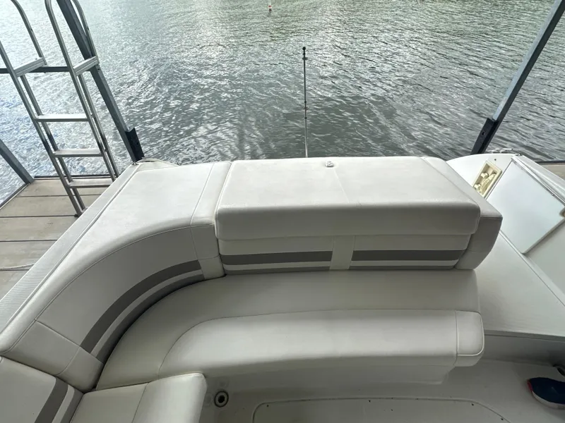 Slide: The Image of 1998 Formula 330 SunSport boat with white seating, docked by calm water. - 11