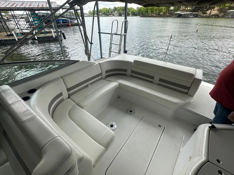 Slide: The Image of 1998 Formula 330 SunSport boat interior with white seating, docked by a lake. - 12