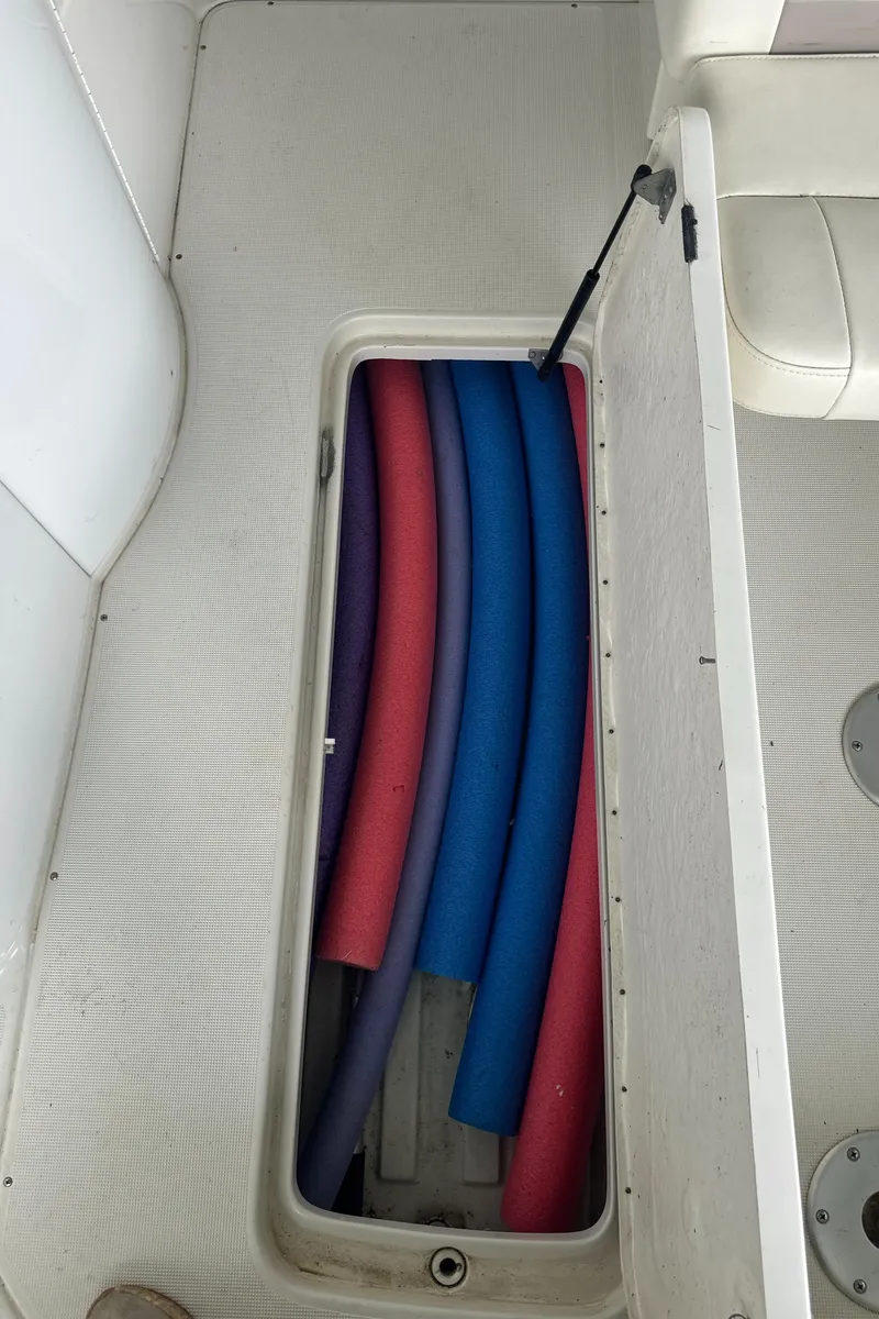 Slide: The Image of Storage compartment on a 1998 Formula 330 SunSport boat with colorful pool noodles. - 19