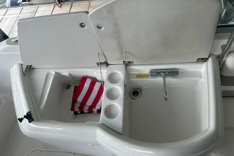 Slide: The Image of 1998 Formula 330 SunSport boat sink with faucet, cup holders, and striped towel. - 21