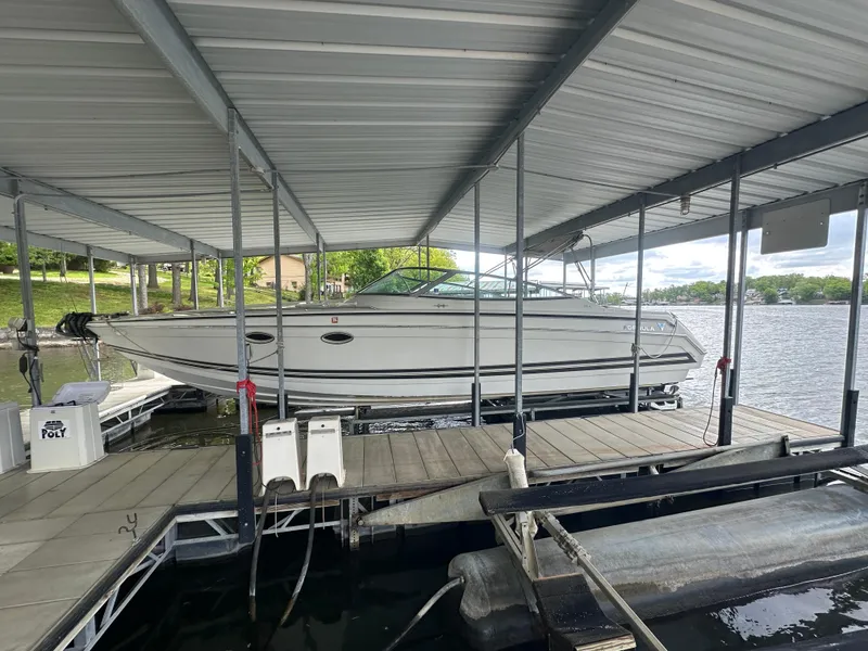 Slide: The Image of 1998 Formula 330 SunSport boat docked under a covered marina on a lake. - 4