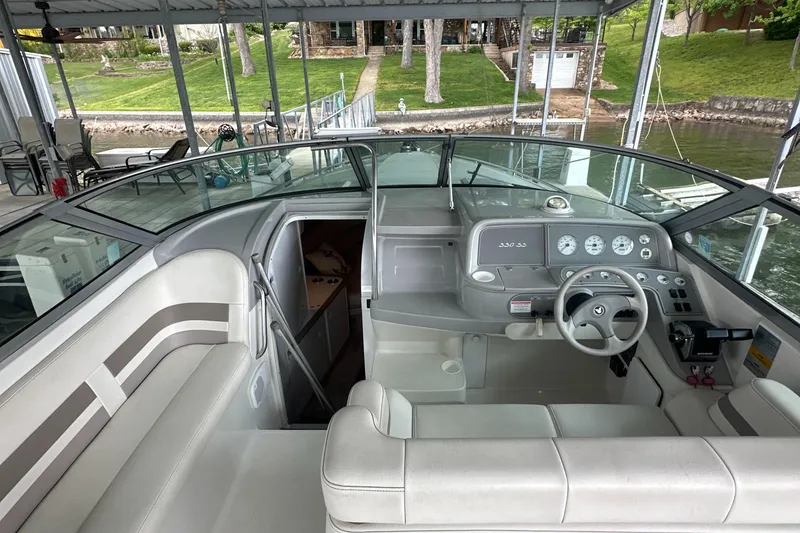 Slide: The Image of 1998 Formula 330 SunSport boat interior with helm, seating, and dock view. - 8