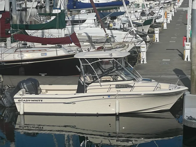 The Image of 2015 Grady-White Seafarer 226 boat docked at a marina, surrounded by other vessels. - 0
