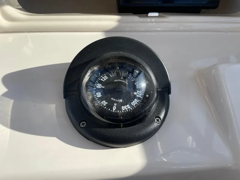 Slide: The Image of Compass on 2015 Grady-White Seafarer 226 boat dashboard, displaying cardinal directions. - 12