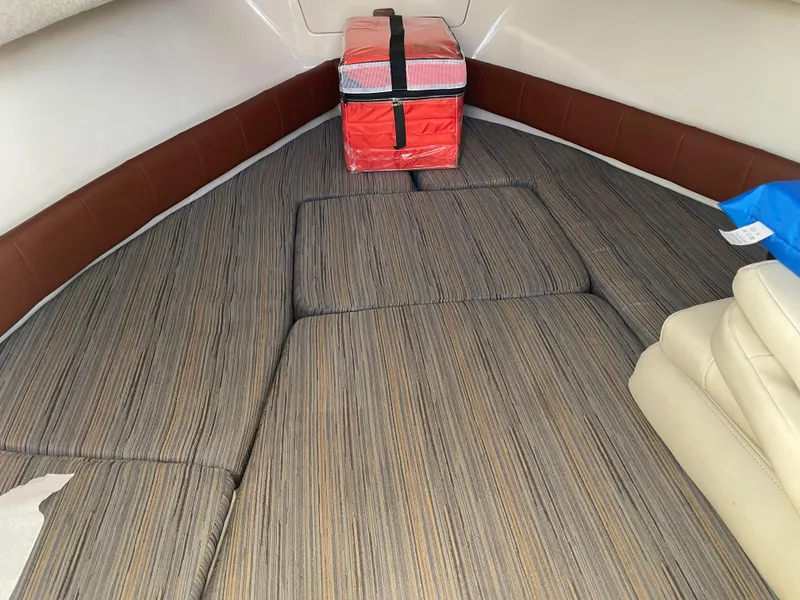 Slide: The Image of 2015 Grady-White Seafarer 226 cabin interior with cushioned seating and a red cooler. - 14