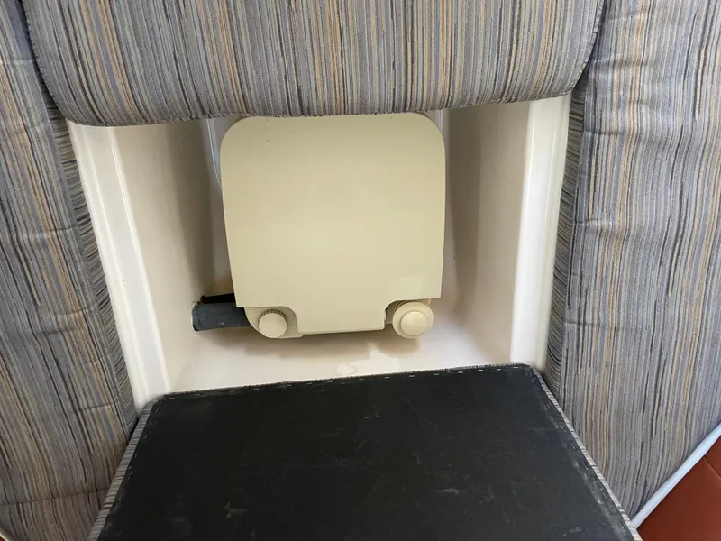 Slide: The Image of Interior detail of a 2015 Grady-White Seafarer 226 boat, featuring a cushioned seat and storage compartment. - 16